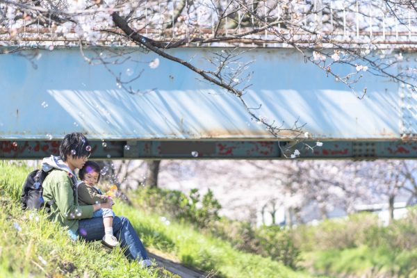 土手でくつろぐ父子